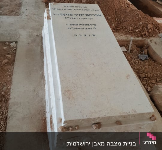מצבה לבנה עם כיתוב בעברית בבית קברות